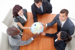 High Angle of businessteam holding a globe in a meeting and businessman smiling upwards. Global business